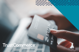 Person holding credit card to make an online patient payment with TrustCommerce logo